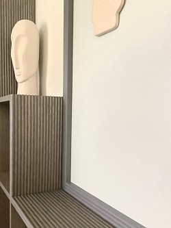 Agencement sur-mesure bibliothèque en bois fraisé, code-couleurs doux ton gris-bleuté